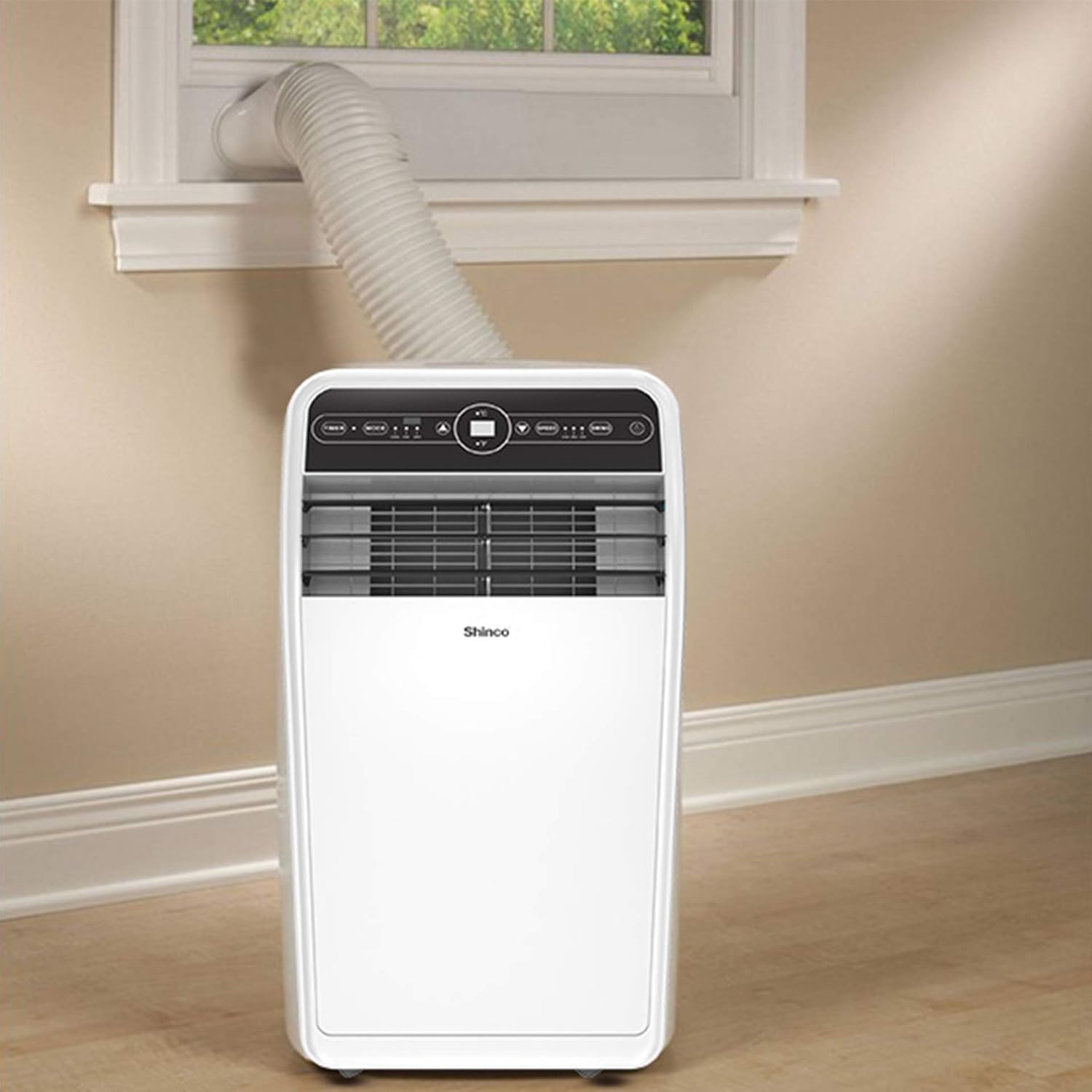 Portable air conditioner with window connection in a room with beige walls and wooden floor.